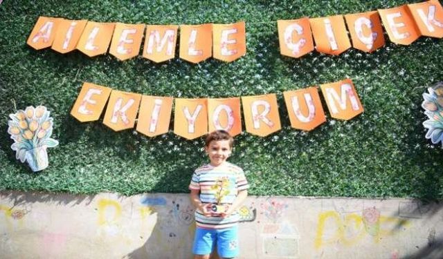 Aileler ve çocuklar, birlikte saksı boyayıp çiçek ekti